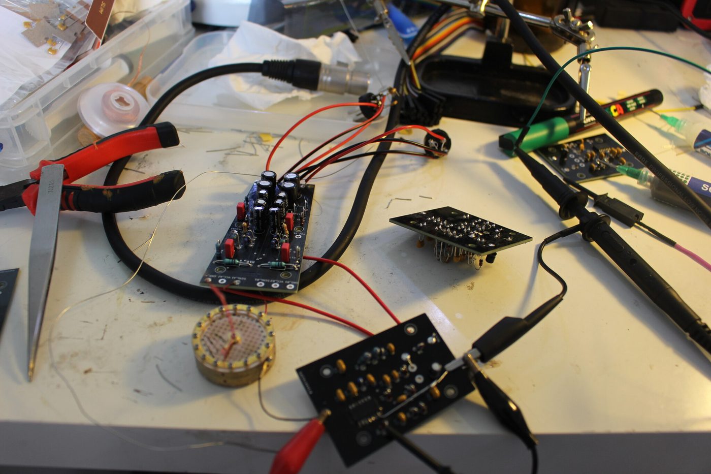 The workbench during testing: boards, crocodile clips, probe, capsule