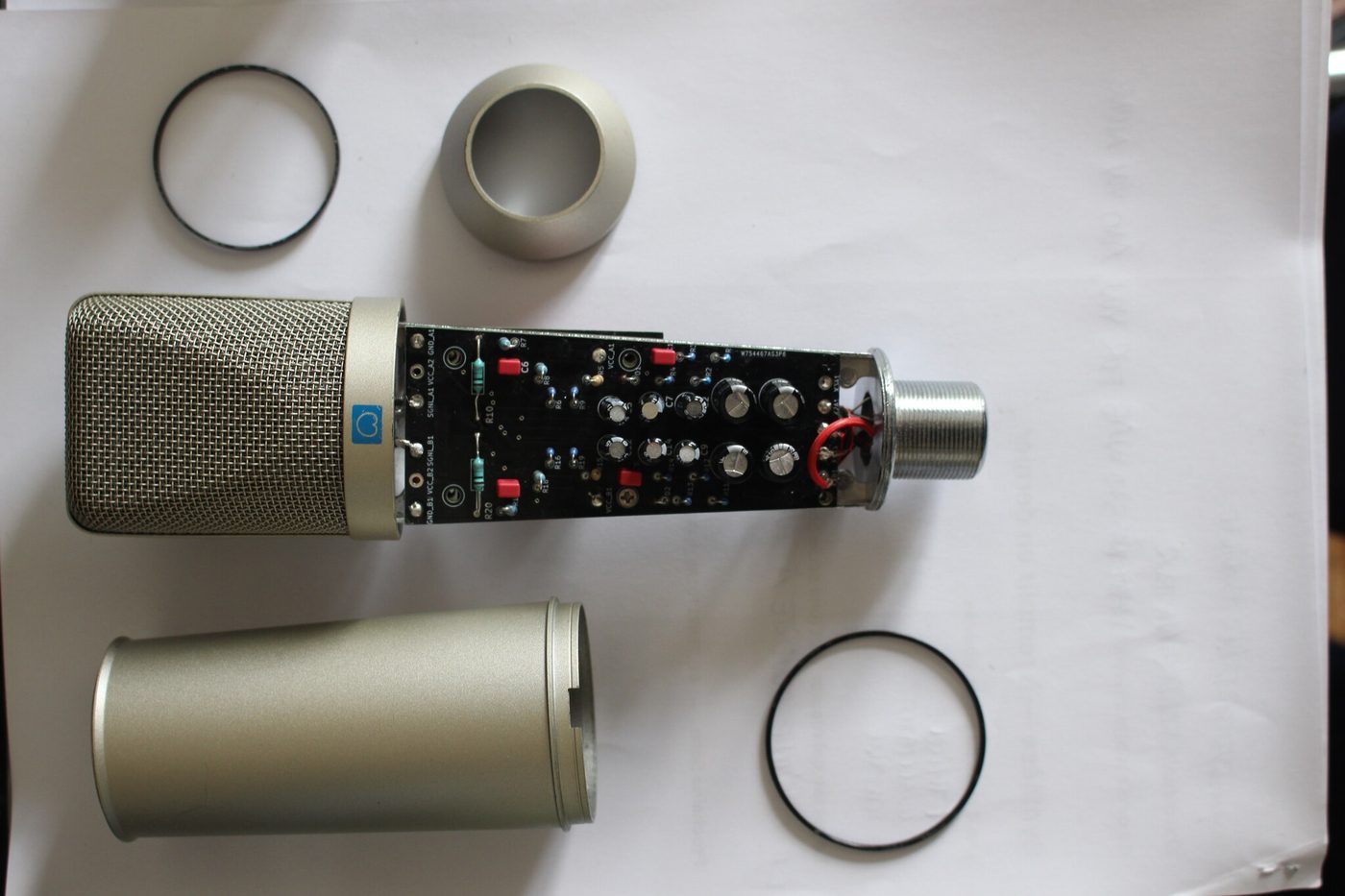 The mic taken apart: grille, body tube, rings, and the long circuit board